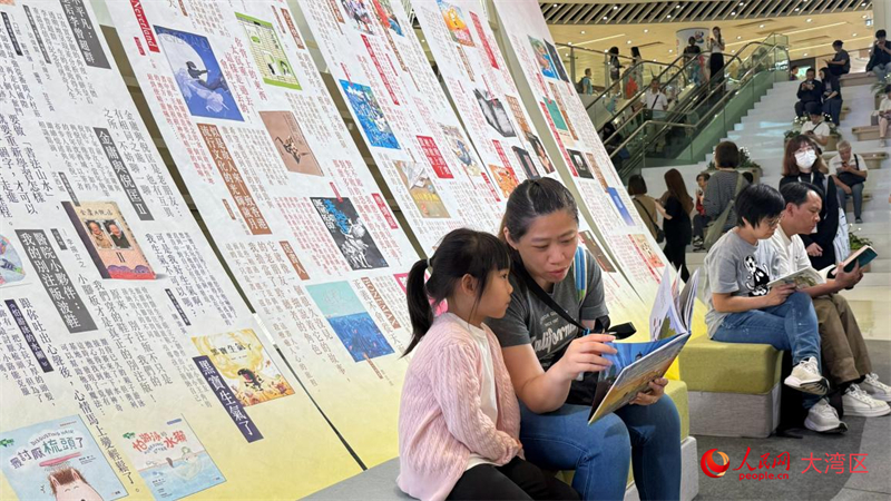 一位妈妈带着小朋友在“共读半小时”活动中阅读。人民网实习生 张雨洁摄